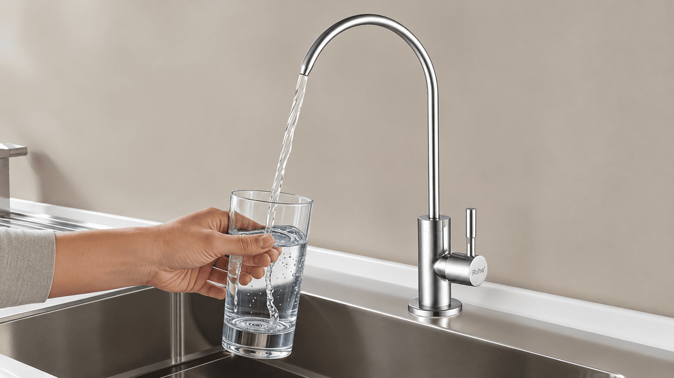 Clear drinking water in a glass beside a kitchen tap, illustrating why appearance alone cannot confirm water safety.