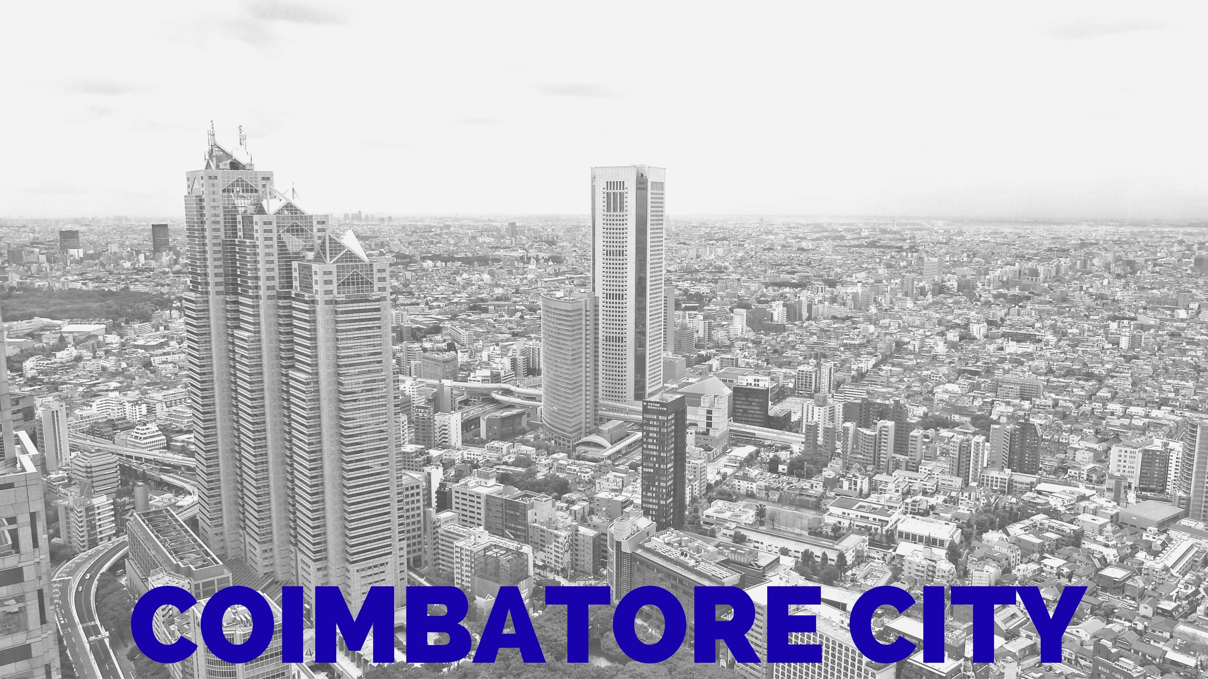"COIMBATORE CITY" banner image for RentOMate blog, featuring a high-angle aerial view of city skyscrapers and urban development in a classic grayscale filter.